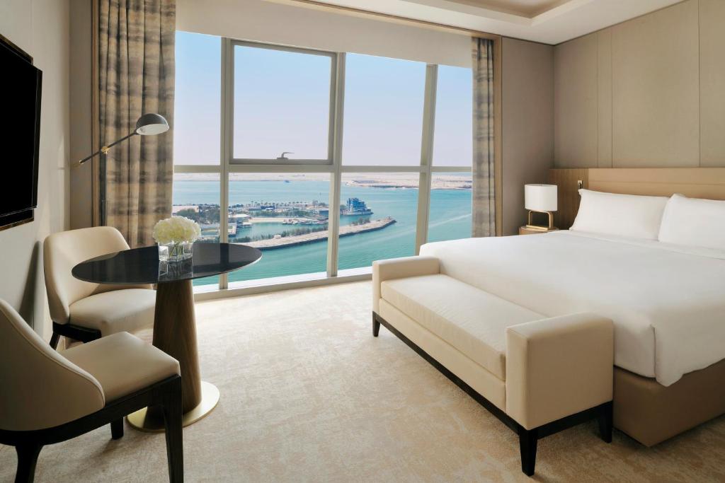 um quarto com uma cama, uma secretária e uma janela grande em InterContinental Residences Abu Dhabi, an IHG Hotel em Abu Dhabi