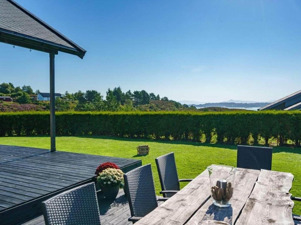 una mesa de madera y sillas en una terraza de madera en 6 person holiday home in TORANGSVÅG-By Traum, en Skår