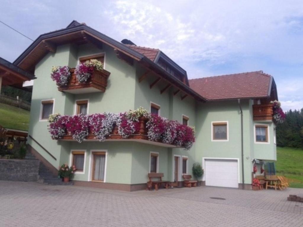ein Haus mit Blumenkästen an der Seite in der Unterkunft Ferienwohnung Kirchblick - a77305 in Liebenfels