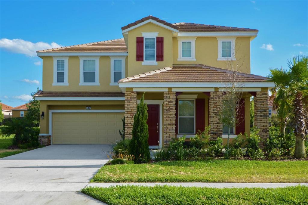 a large yellow house with a garage at Serene Bliss at Ellis Exclusive Villas in Davenport