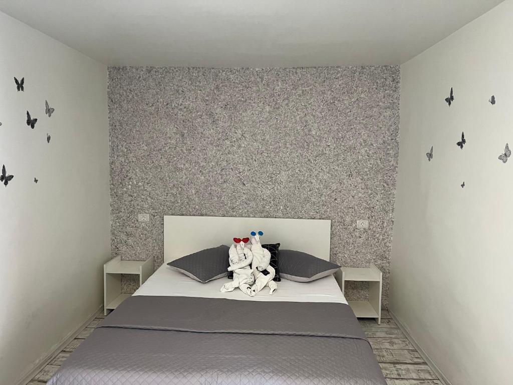 dois bichos de peluche sentados numa cama num quarto em AmA em Constança