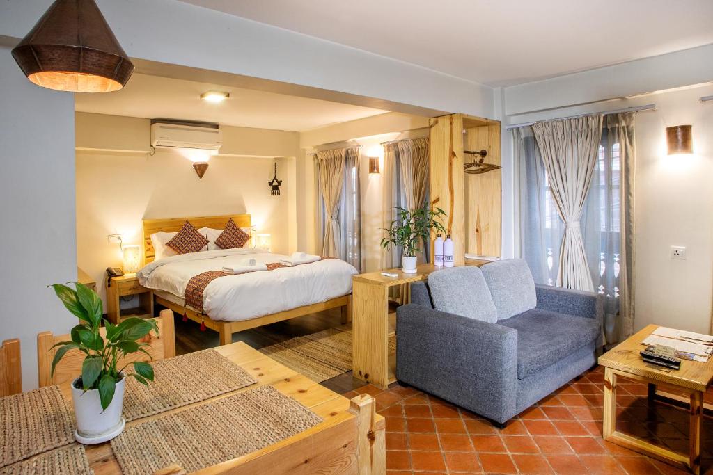 ein Hotelzimmer mit einem Bett und einem Stuhl in der Unterkunft Hotel Timila in Pātan