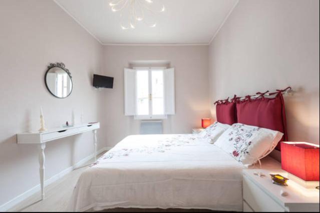 ein weißes Schlafzimmer mit einem Bett und einem Fenster in der Unterkunft Appartamento Toscanella in Florenz