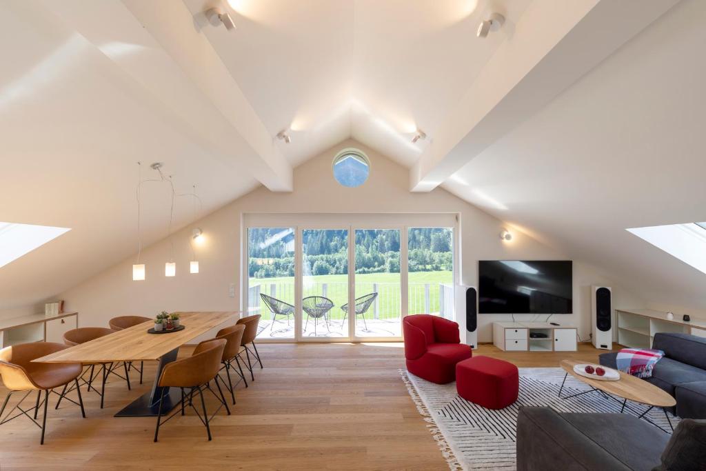 - un salon avec une table, des chaises et une télévision dans l'établissement Ferienwohnungen Friedenshöhe in Oberammergau, à Oberammergau