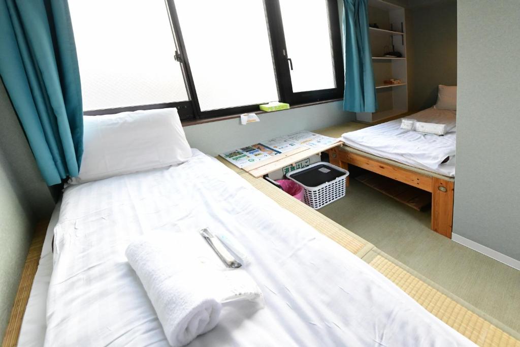 Jing House akihabara Ryokan - Vacation STAY 30899v في طوكيو: غرفة عليها سرير وفوط