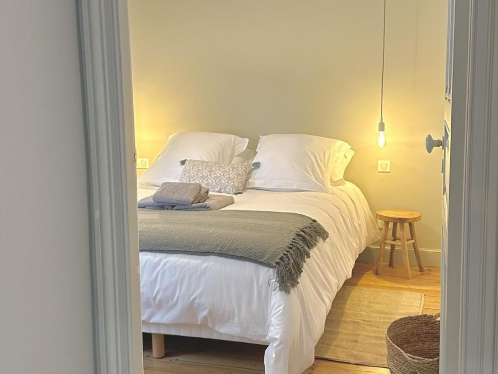 a bedroom with a bed with white sheets and pillows at La Maison Harmony in Beuvron-en-Auge