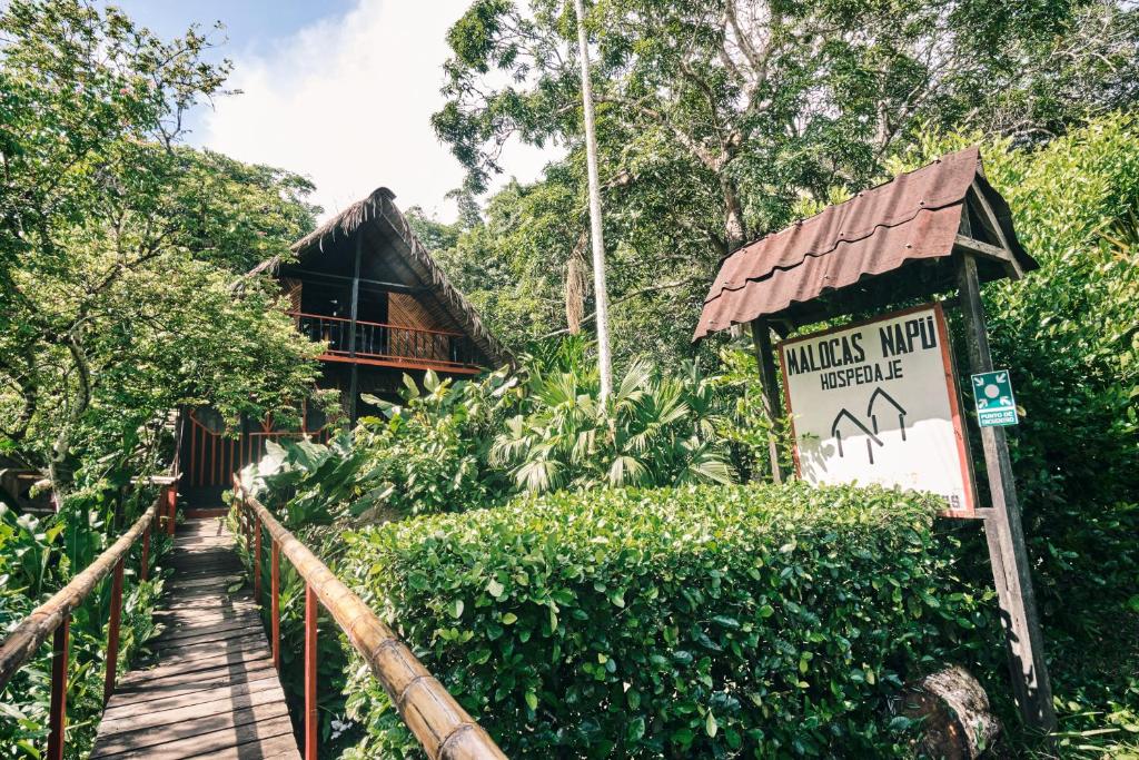 un panneau devant un bâtiment avec un pont dans l'établissement Maloka Napü - Ecodestinos, à Puerto Nariño