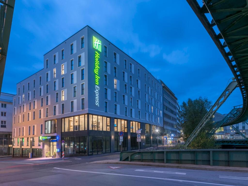 budynek z zielonym znakiem na boku w obiekcie Holiday Inn Express - Wuppertal - Hauptbahnhof, an IHG Hotel w mieście Wuppertal