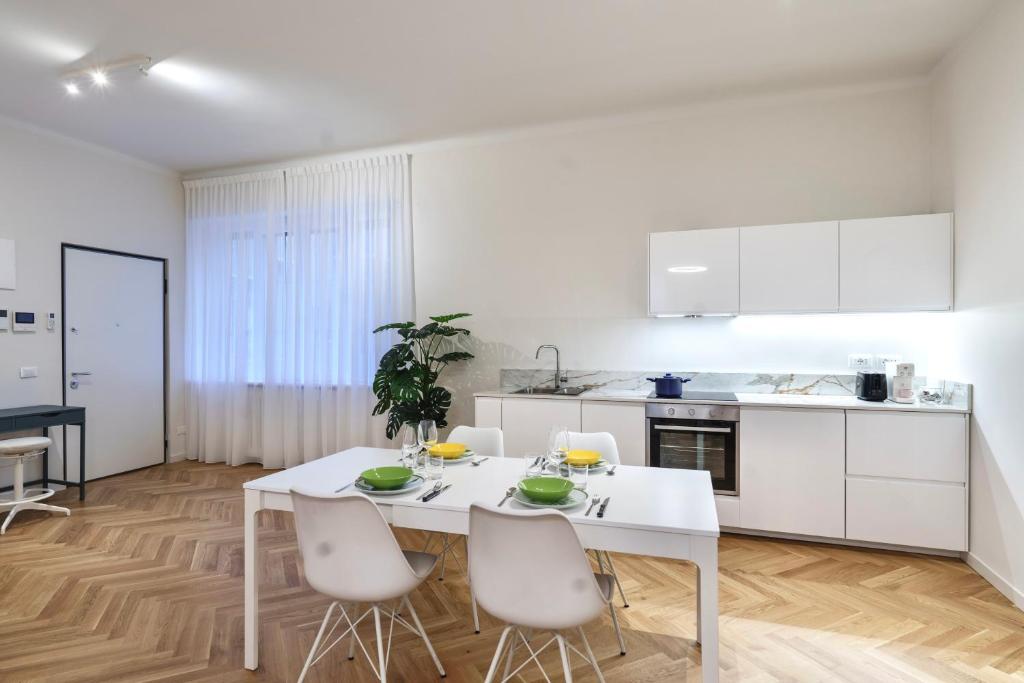 a white kitchen with a white table and chairs at PORTA VENEZIA-TRILOCALE-LUXURY con Wifi-Neflix in Milan