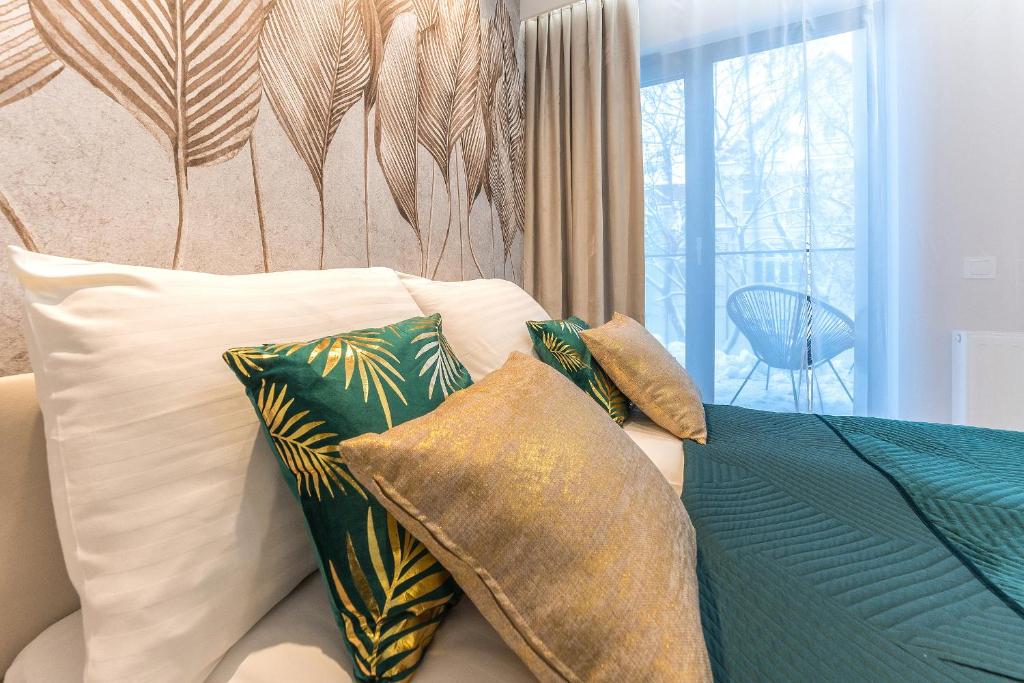 1 dormitorio con sofá con almohadas y ventana en Pomorskie Apartamenty Monte Cassino 27 Deluxe en Sopot