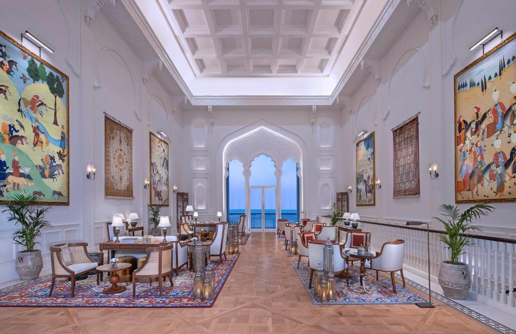 una hall con tavoli e sedie in un edificio di The Chedi Katara Hotel & Resort a Doha