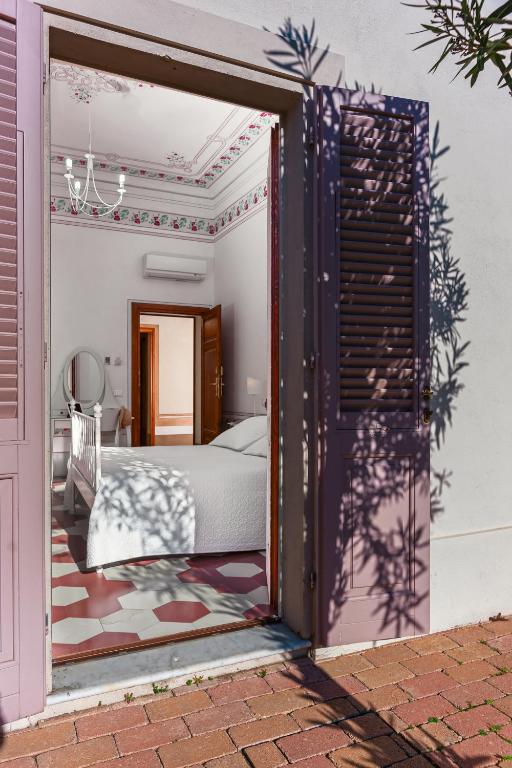 a bedroom with a bed through a sliding glass door at Villino Ermione in Marina di Pisa