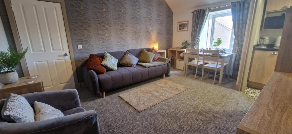 a living room with a couch and a table at Mains Street Retreat in Lockerbie