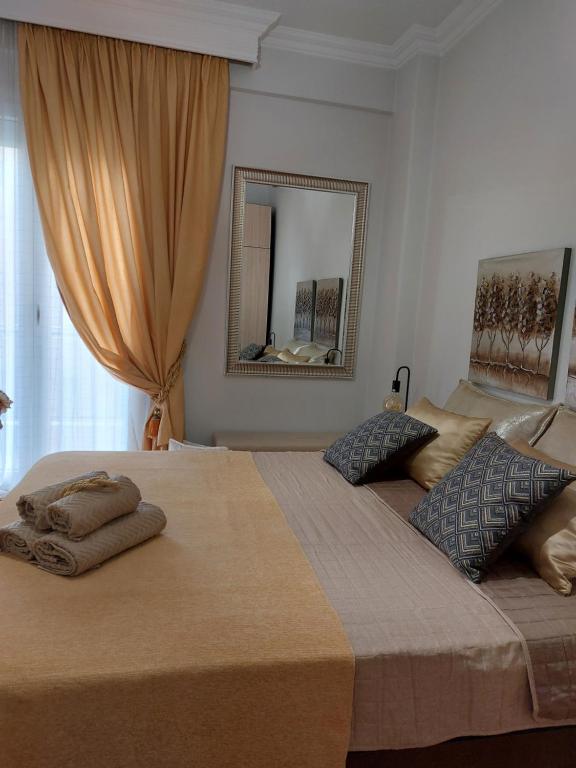 een slaapkamer met 2 bedden en een spiegel bij Antigonidon Square Luxury Apartment in Thessaloniki