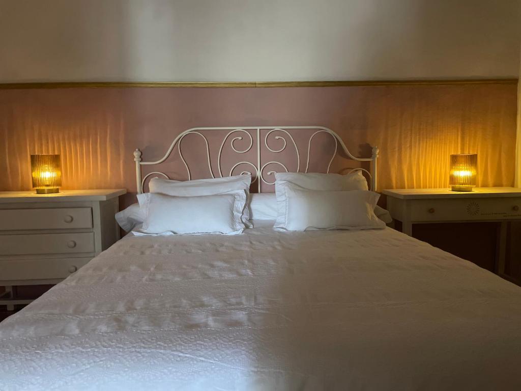 a bedroom with a white bed with two lamps at Marisa Home in Orzola