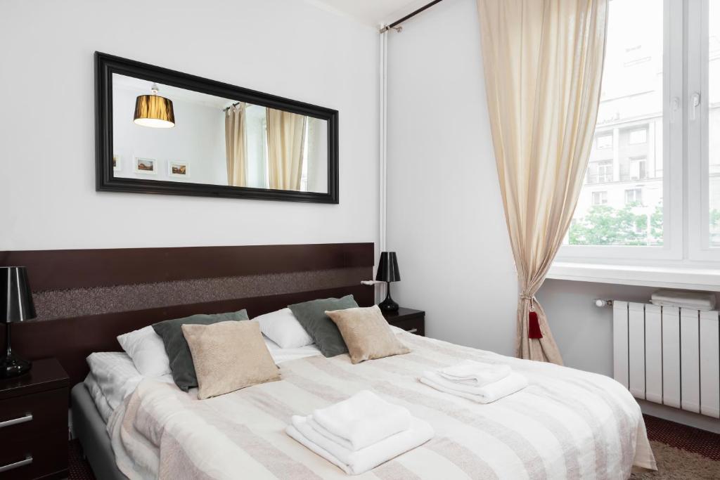1 dormitorio con 1 cama con espejo en la pared en Stars Apartaments City Center by Renters, en Varsovia