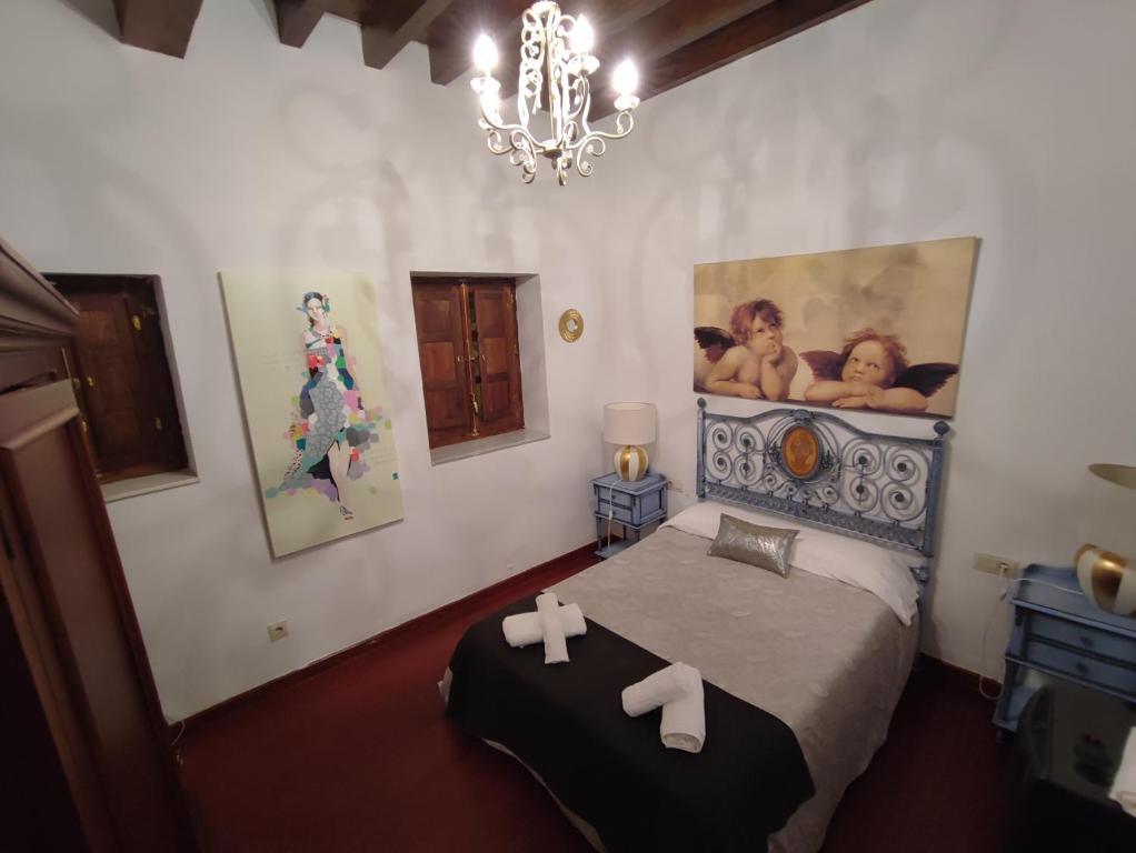 a bedroom with a bed and a chandelier at Apartamento con zona chill-out y preciosas vistas in Granada