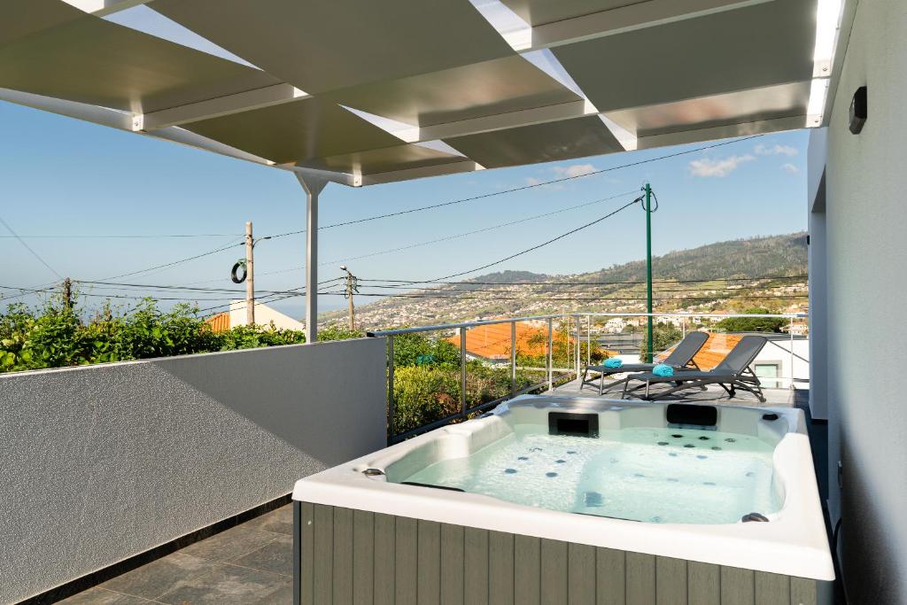 bañera de hidromasaje en el balcón de una casa en Casa Alan by Rent2u, Lda en Arco da Calheta