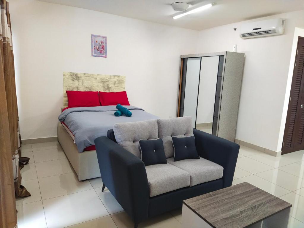 a bedroom with a bed and a couch and a chair at Trefoil in Setia Alam