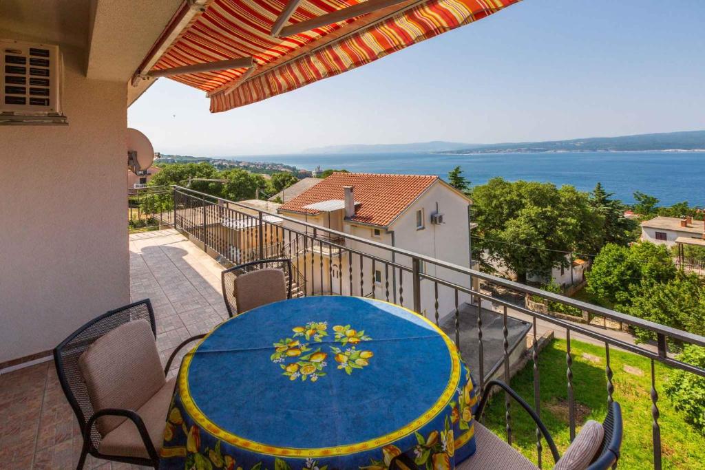 a table on a balcony with a view of the water at Apartment in Crikvenica 14098 in Dramalj