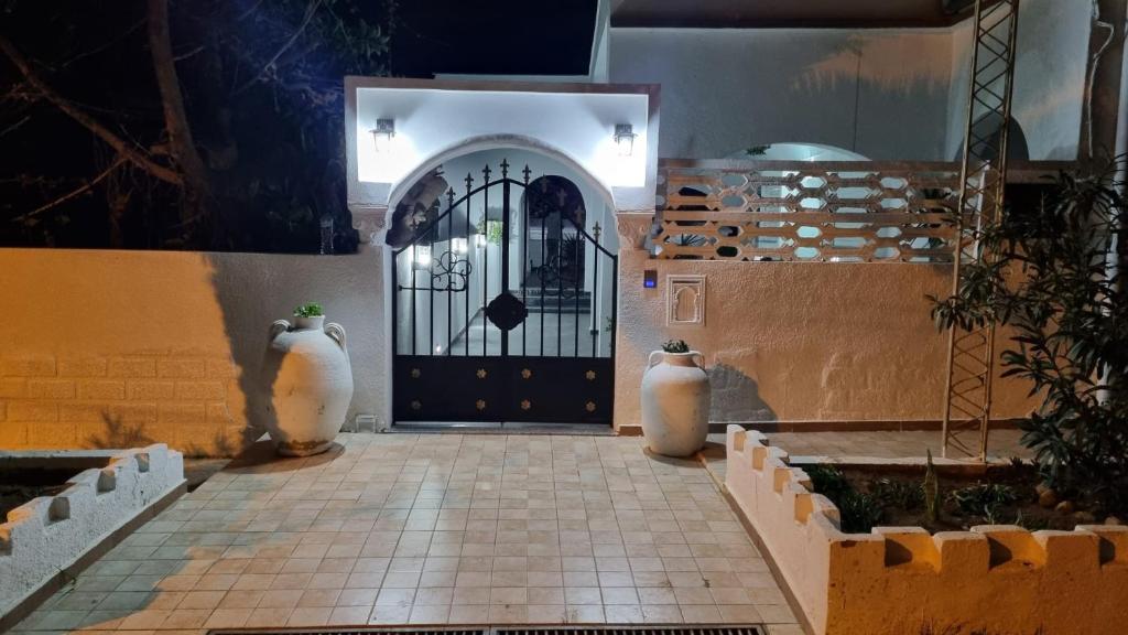 an entrance to a building with a black door at Maison du Cap Bon,Ben Hamida in El Haouaria