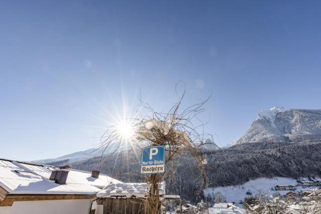 a parking sign in the snow next to a house at Ferienwohnungen Kaspern in Ramsau