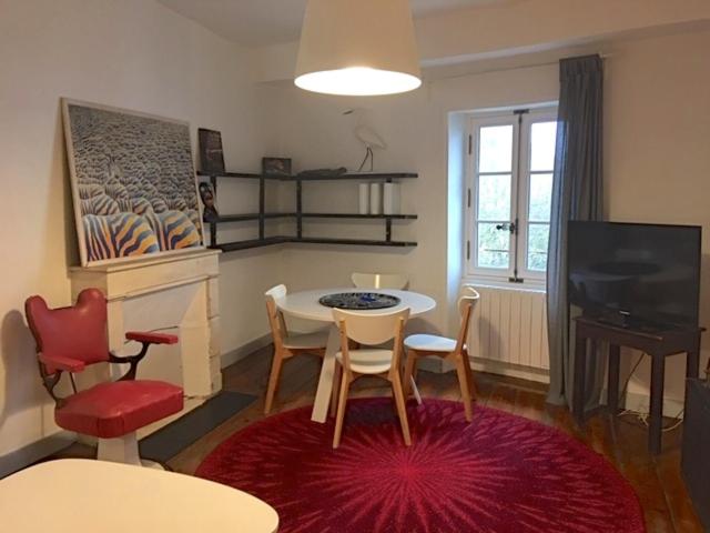 - un salon avec une table, des chaises et une télévision dans l'établissement Dormir à la Rochelle 2, à La Rochelle
