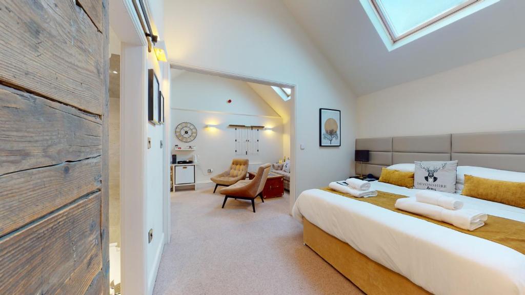 a bedroom with a large bed and a living room at The Devonshire Arms in Eckington
