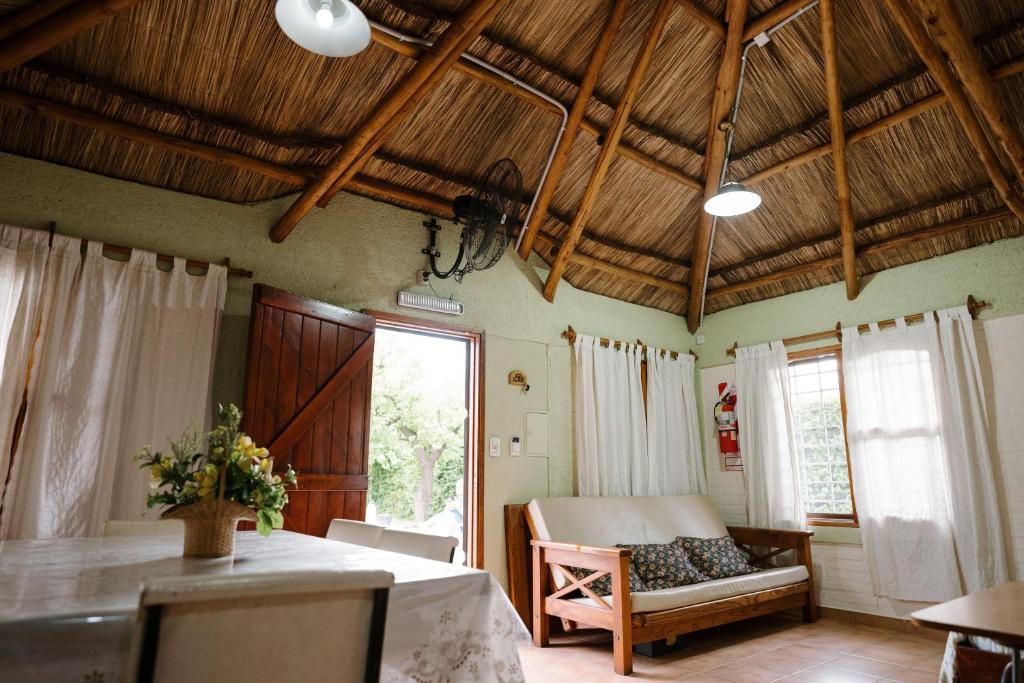 uma sala de estar com uma mesa, uma cama e uma janela em Jumani Cabañas em San Rafael