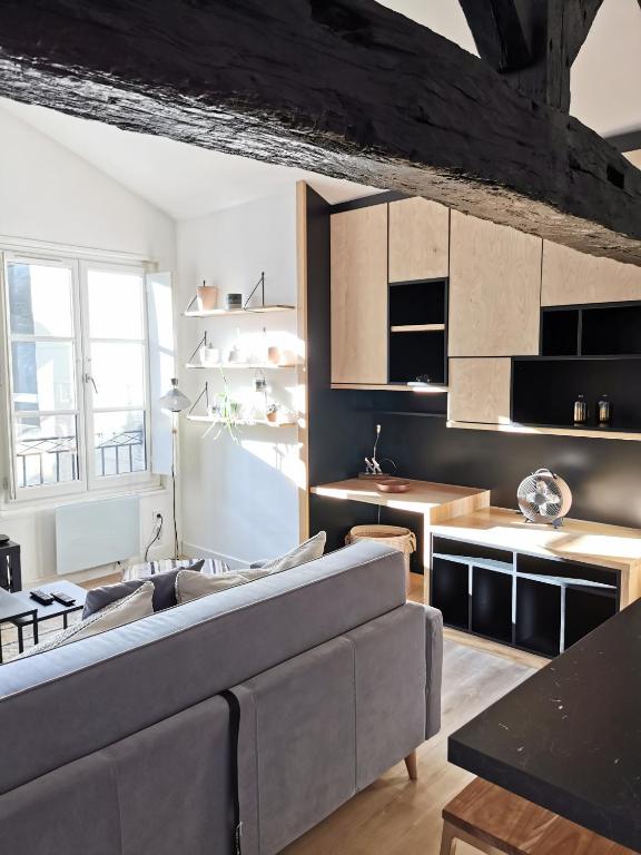 a living room with a couch and a kitchen at Bordeaux Chéri in Bordeaux