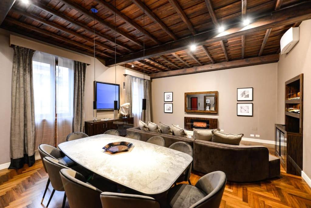 sala de estar con mesa y sillas en The Frattina - Luxury Serviced Apartment, en Roma
