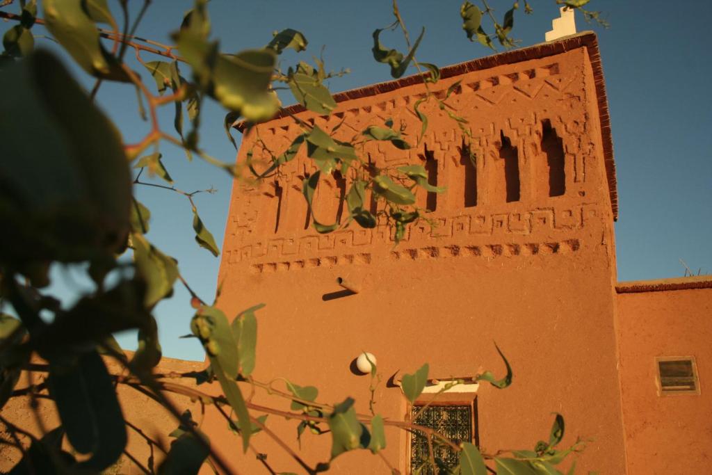 a building with writing on the side of it at Riad Paradise of Silence in Aït Benhaddou