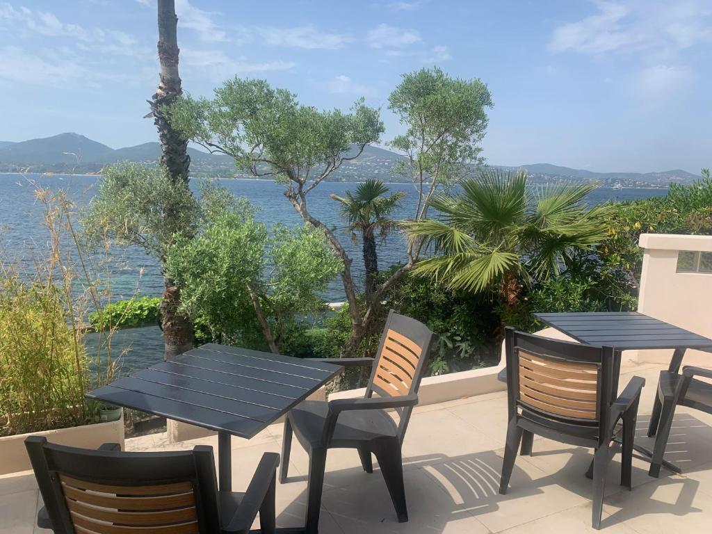 a table and chairs on a patio with a view of the water at Loustalou in Saint-Tropez