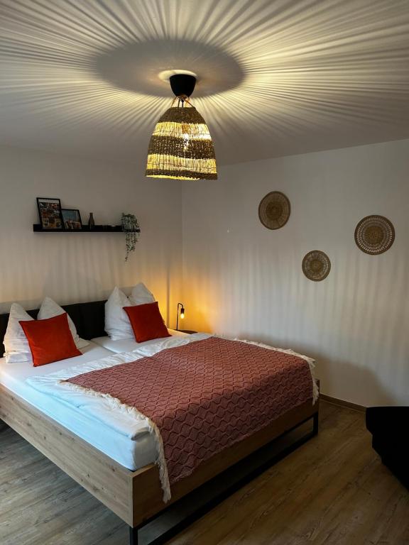 a bedroom with a bed with red pillows and a ceiling at Ferienwohnung II Beck-Bräu nahe Bamberg in Lisberg