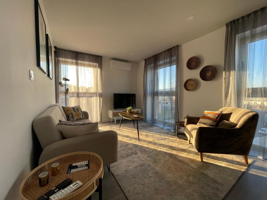 a living room with two couches and a tv at Retiro em Valença in Valença