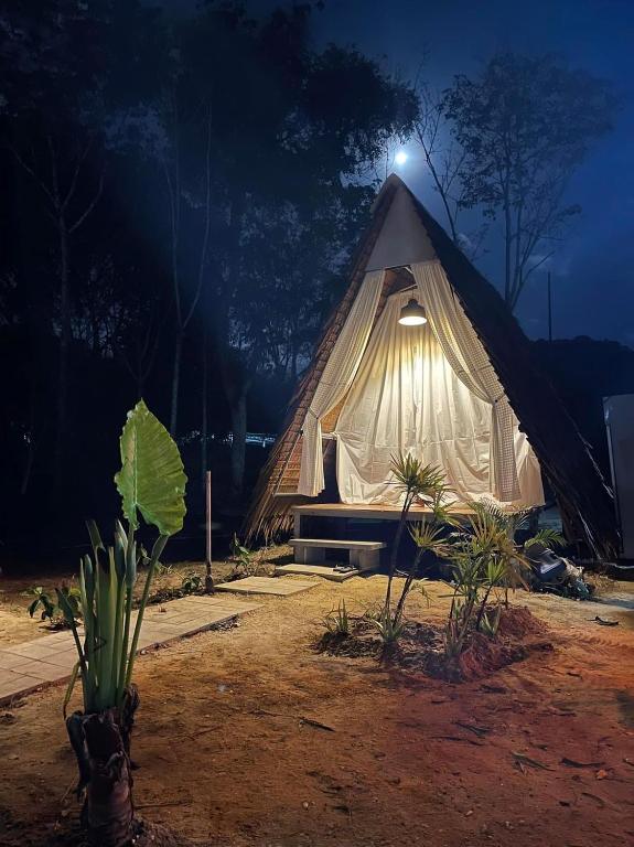 a tent with a light on the top at night at PhuketAirportCamping in Mai Khao Beach