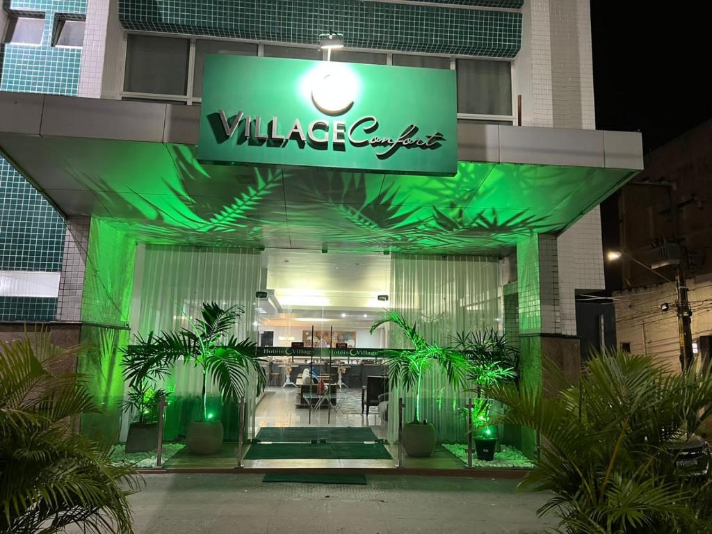 a building with a green sign on the front of it at Hotel Village in Garanhuns