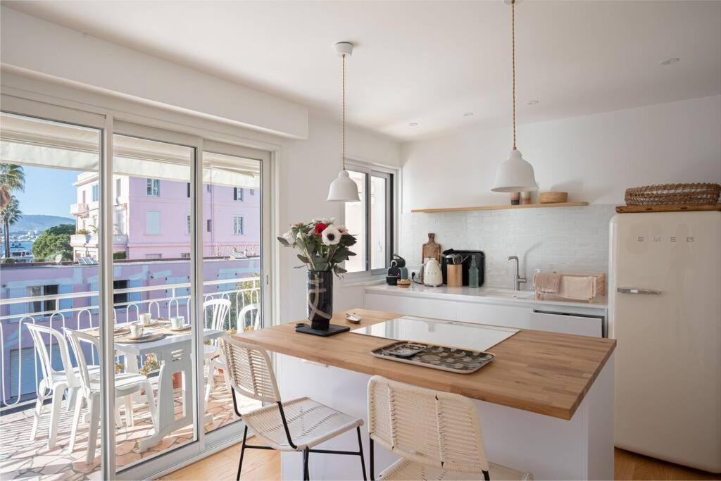 a kitchen with a table and chairs and a balcony at Le Petit Palais in Cannes