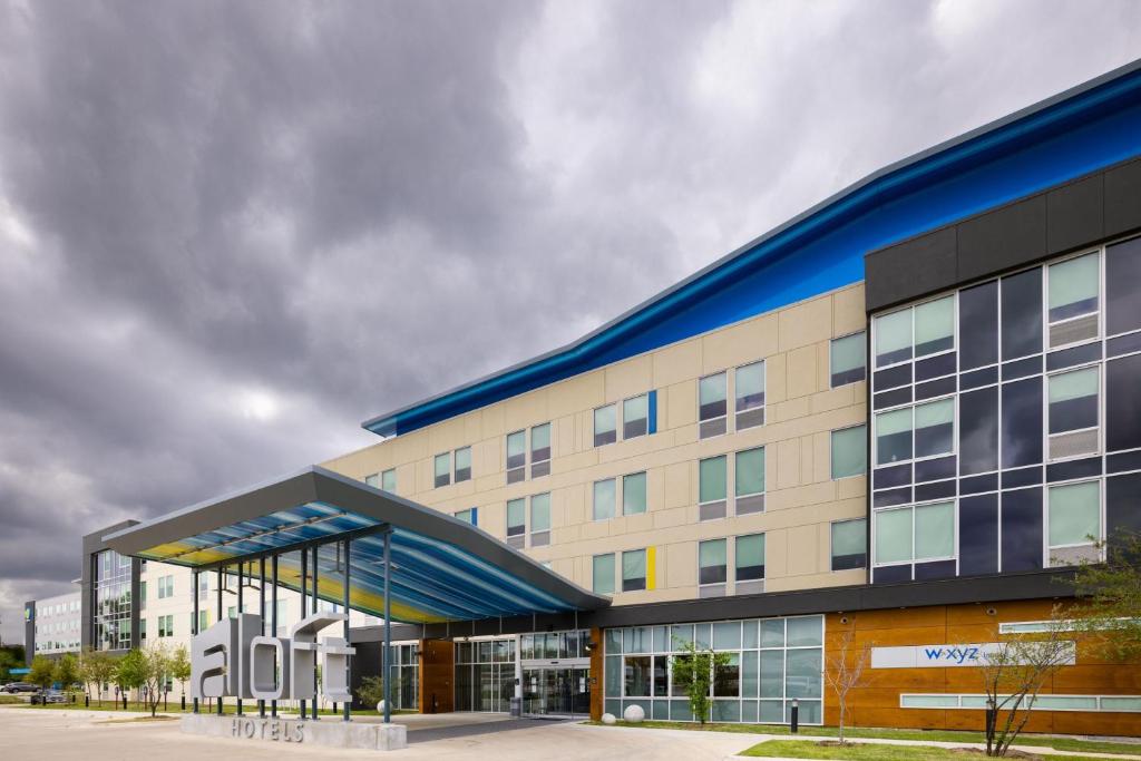 a large office building with a blue roof at Aloft Austin Airport in Austin