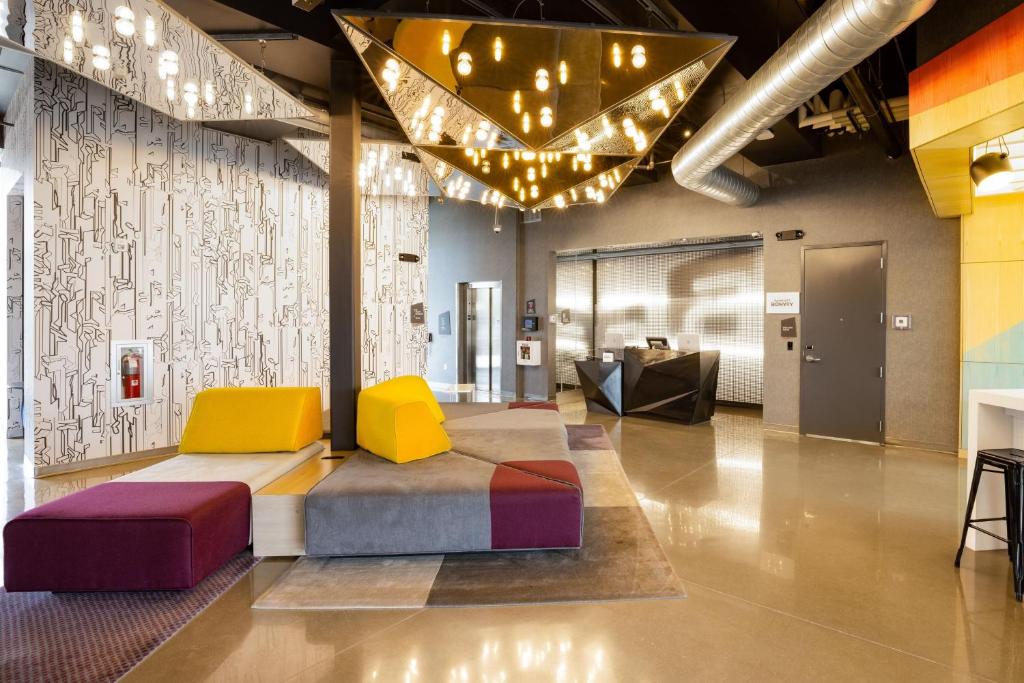 a lobby with colorful chairs and a couch at Aloft Austin Airport in Austin