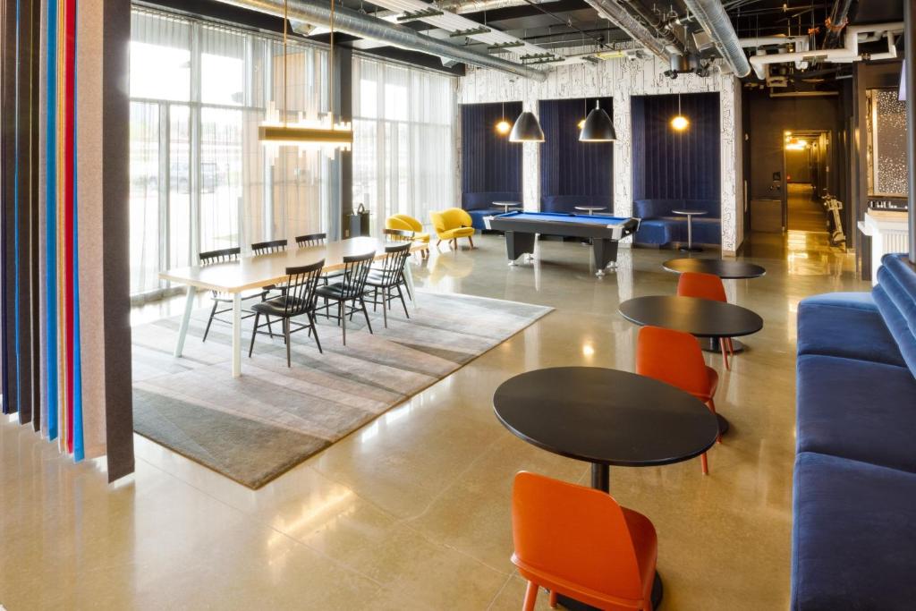 a living room with tables and chairs and a pool table at Aloft Austin Airport in Austin