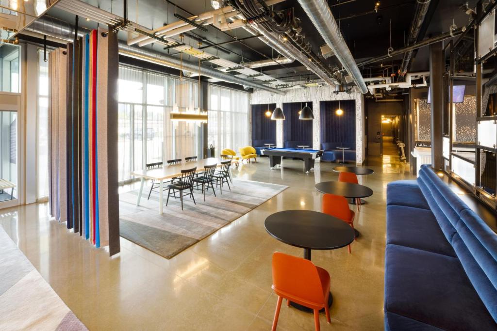 a room with tables and chairs and a pool table at Aloft Austin Airport in Austin