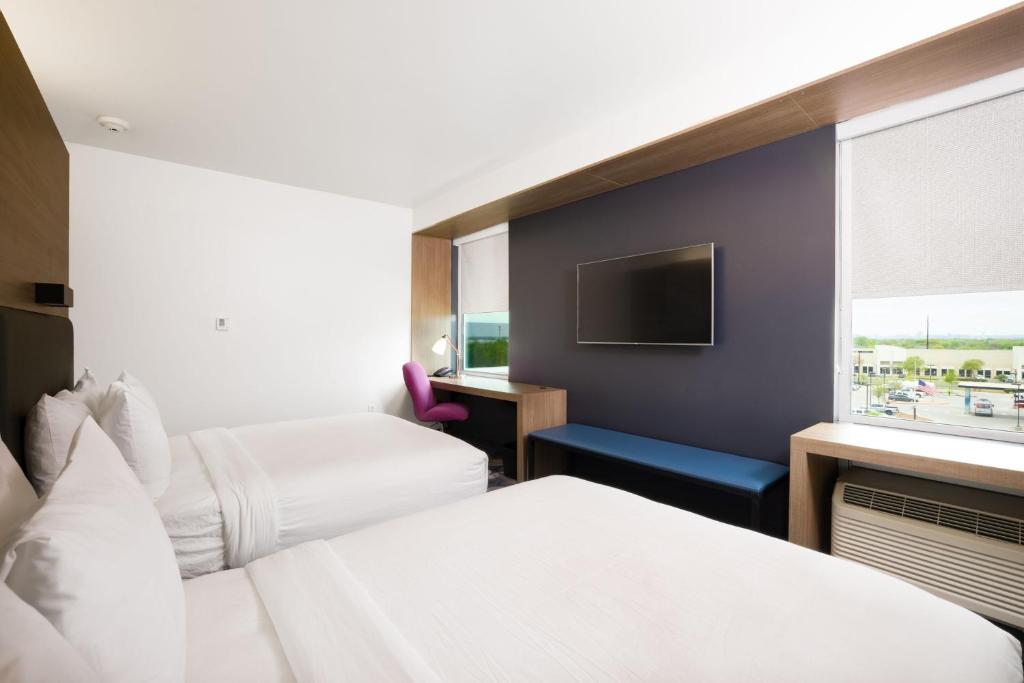 a hotel room with two beds and a tv at Aloft Austin Airport in Austin