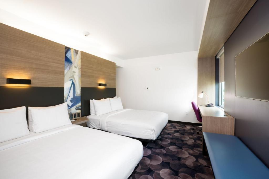 a hotel room with two beds and a tv at Aloft Austin Airport in Austin
