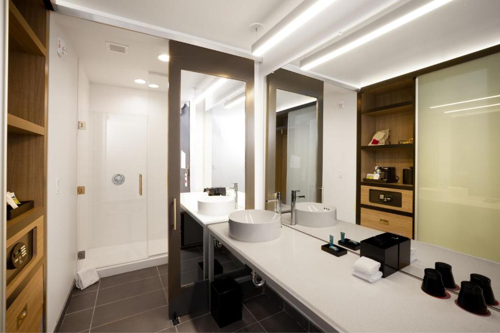 a bathroom with two sinks and a large mirror at Aloft Austin Airport in Austin