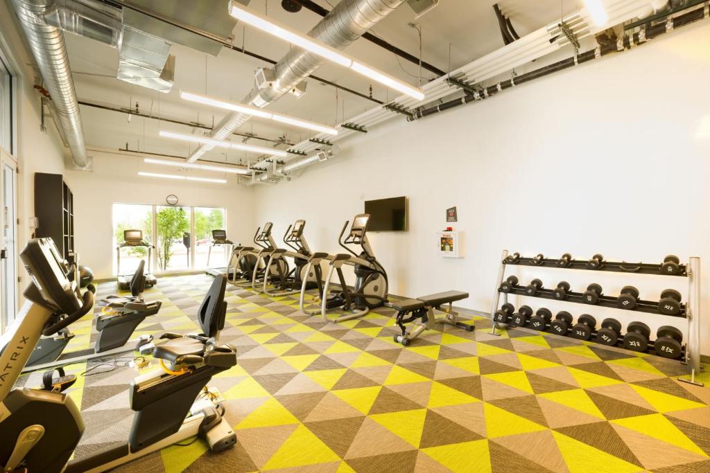 a gym with treadmills and elliptical machines at Aloft Austin Airport in Austin