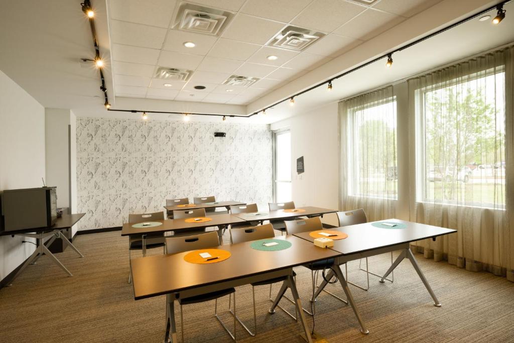 a classroom with tables and chairs in a room at Aloft Austin Airport in Austin