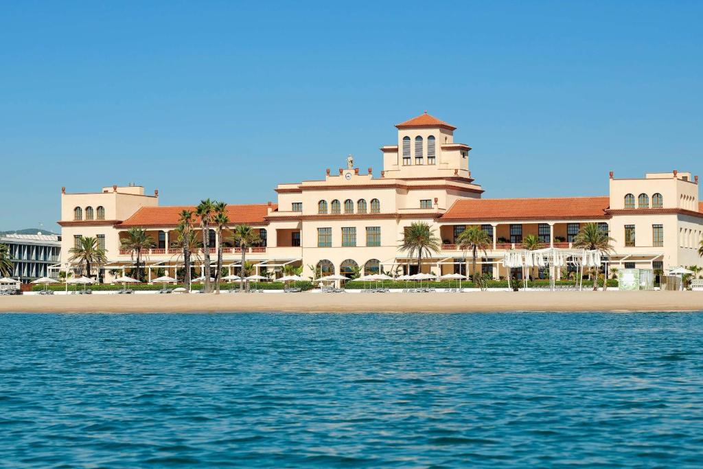 een groot gebouw op een strand aan het water bij Le Meridien Ra Beach Hotel and Spa in El Vendrell