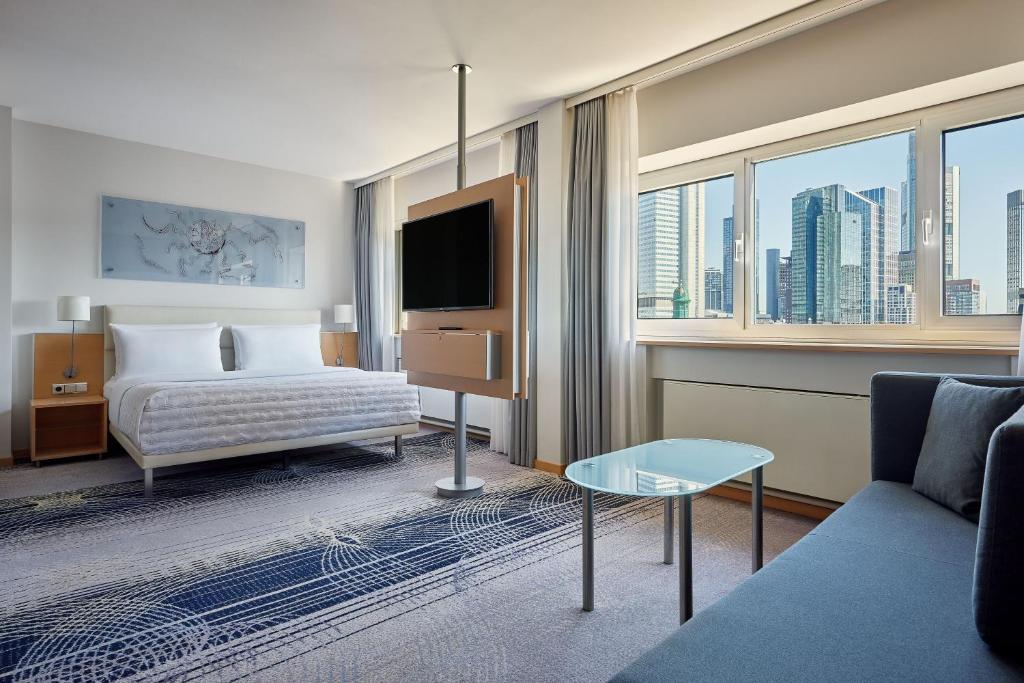 ein Hotelzimmer mit einem Bett und einem TV in der Unterkunft Le Méridien Frankfurt in Frankfurt am Main