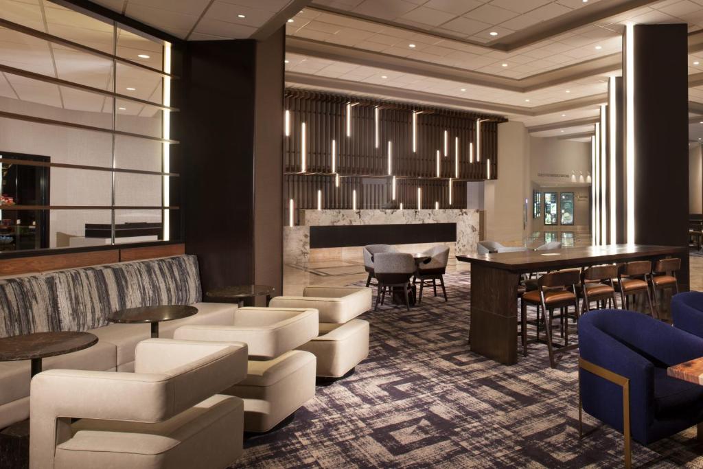 a lobby with a bar and tables and chairs at Dallas/Fort Worth Airport Marriott in Irving